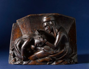 A misericord of a women picking nits [?] from the RAMM Hems Collection